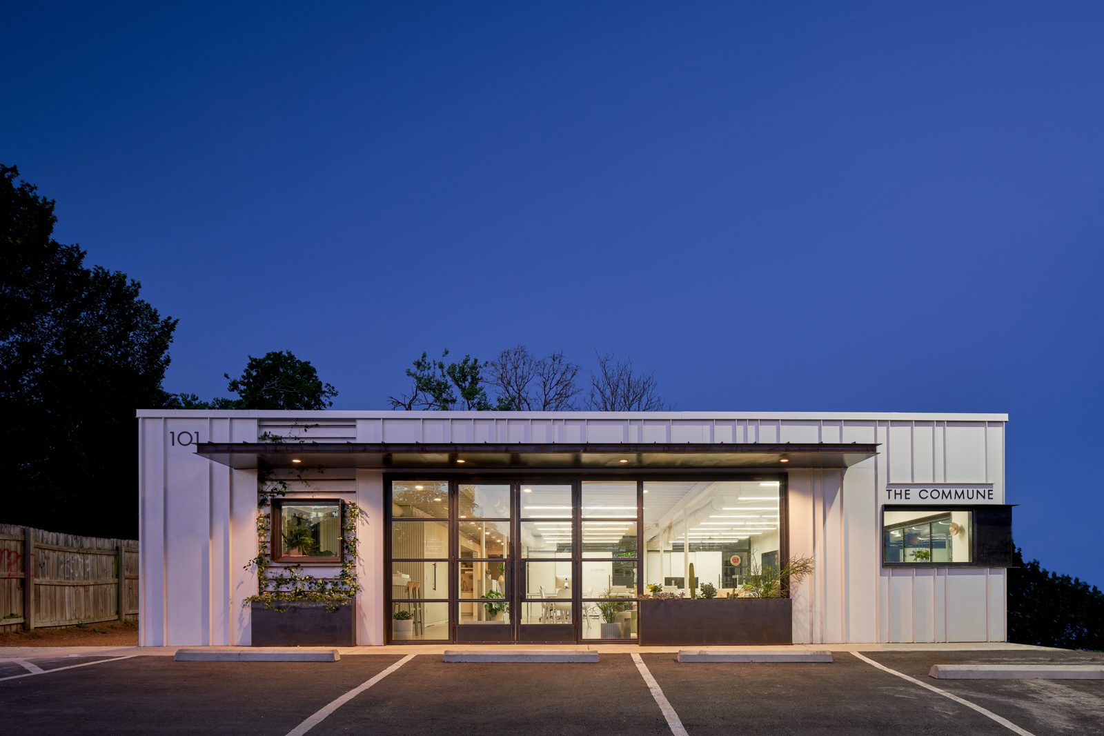 A bright, glass-fronted private event space in central Austin, lit warmly at dusk